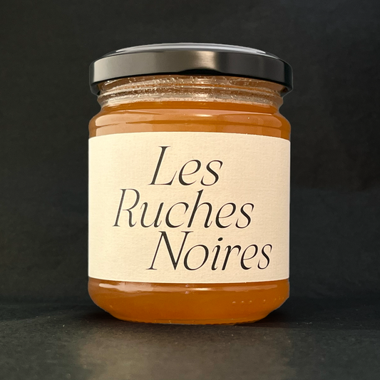 Pot de miel du rucher Convention, étiquette Les Ruches Noires visible – miel de Paris extrait ruche par ruche