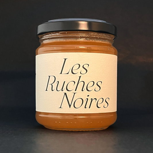 Pot de miel du rucher Champ de Mars, étiquette Les Ruches Noires visible – miel de Paris extrait ruche par ruche